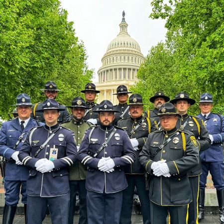 Law enforcment officers in dress uniforms standing in front of US Capitol