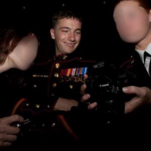 three people, one in dress uniform, the others with their faces blurred