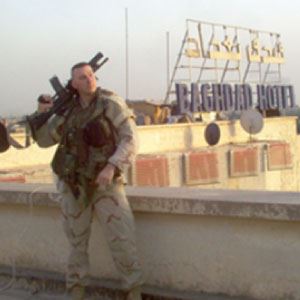 person carrying military weaponry standing near Baghdad Hotel