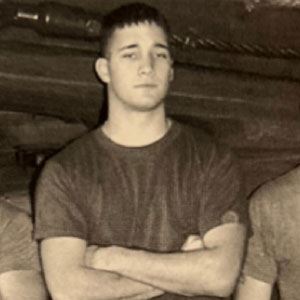 young man with serious facial expression and arms crossed